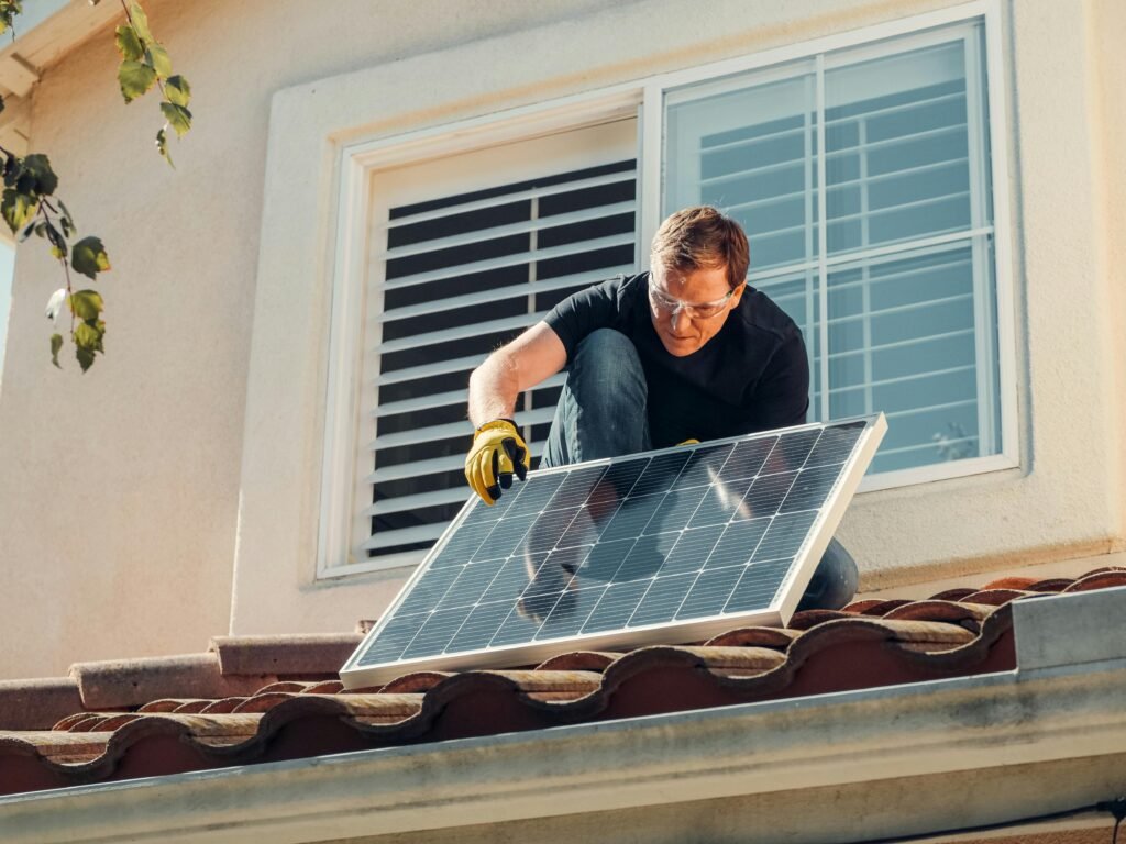 pexels-photo-9875408-9875408 Solar technician installing a photovoltaic panel on a rooftop, promoting renewable energy.